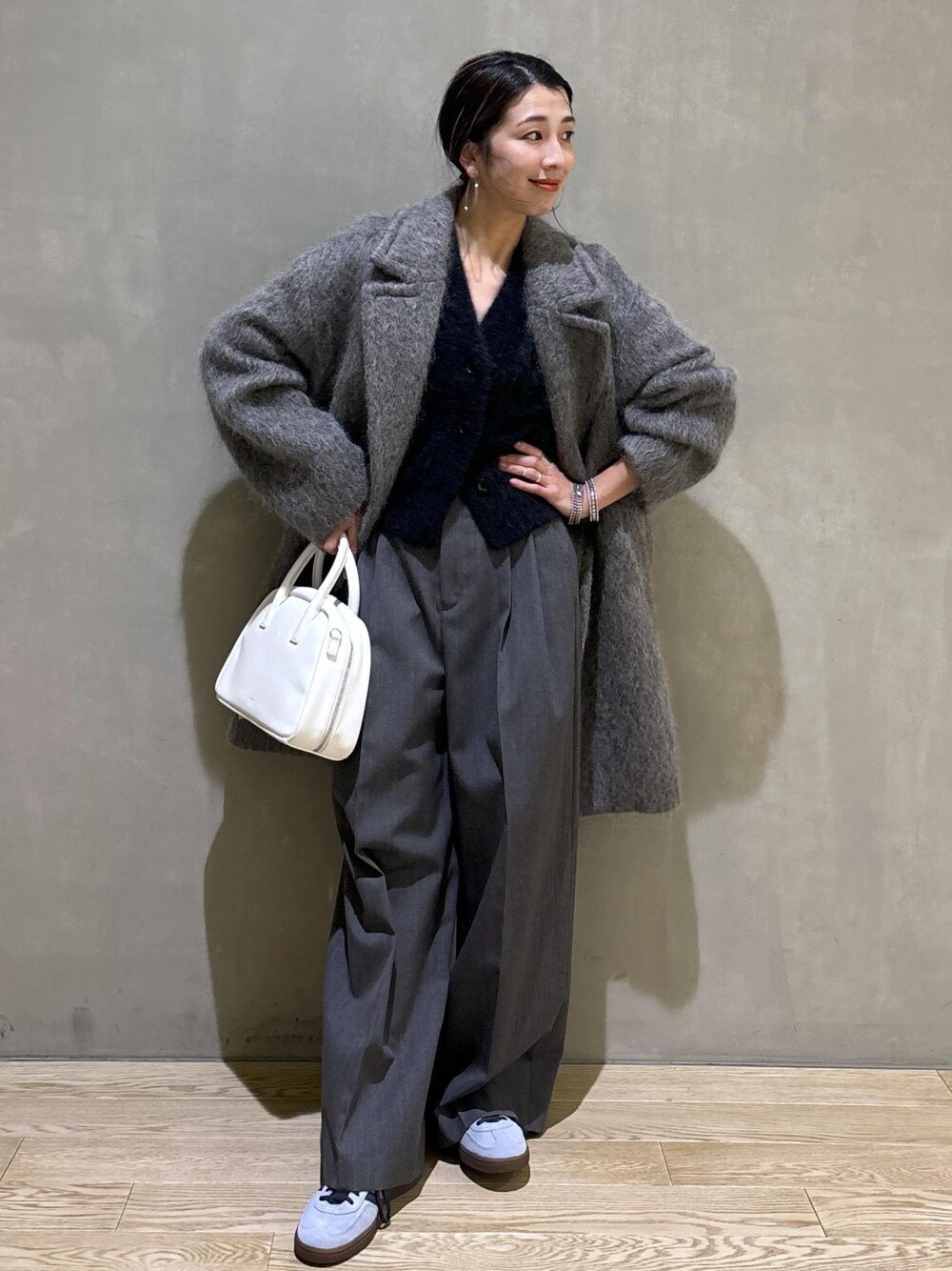 ホワイト系のボストンバッグ、グレー系のカーディガン/ボレロ、グレー系のチェスターコートを着用したレディースの秋コーディネートの1枚目の写真