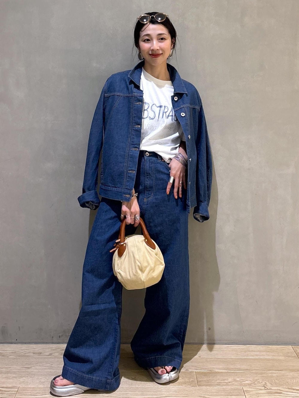 ブルー系のブルゾン、ブルー系のデニムパンツ、ホワイト系のTシャツ/カットソーを着用したレディースの春コーディネートの1枚目の写真