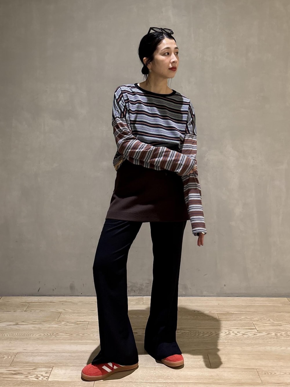 ブラック系のスラックス、ブラウン系のスカート、ブラック系のTシャツ/カットソーを着用したレディースの秋コーディネートの1枚目の写真