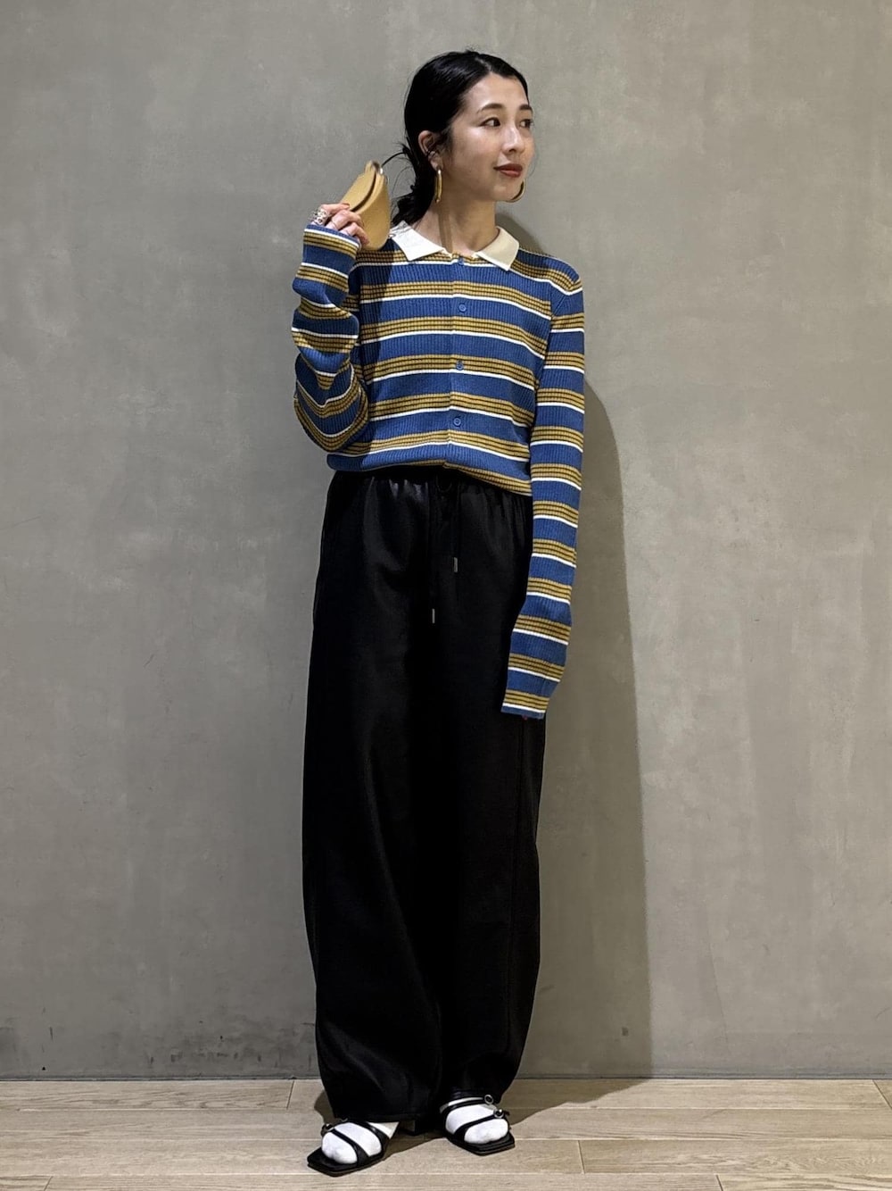 ブルー系のポロシャツ、ブラック系のその他パンツ、イエロー系のキーホルダーを着用したレディースの秋コーディネートの1枚目の写真