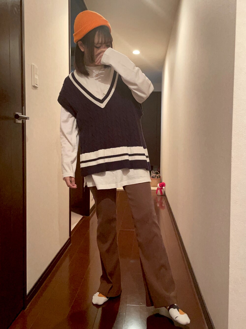 「パンツスタイル、ベスト、ニット帽、カジュアル、ストリート、メンズライク、ニットベスト、蛍光カラー、フレアパンツ、スラックス、ロンT、レイヤードスタイル、ブラウン、オレンジ」｜「SHEINのアイテム（ニットキャップ/ビーニー、オレンジ系）」を使った、あみちゃさん（レディース・156cm）の春コーディネートの1枚目の写真