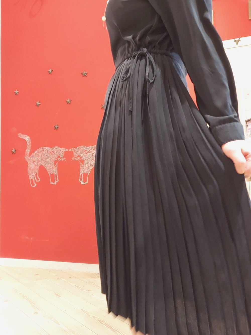 ブラック系のパンプス、ブルー系のワンピース、シルバー系のネックレスを着用したレディースの冬コーディネートの2枚目の写真