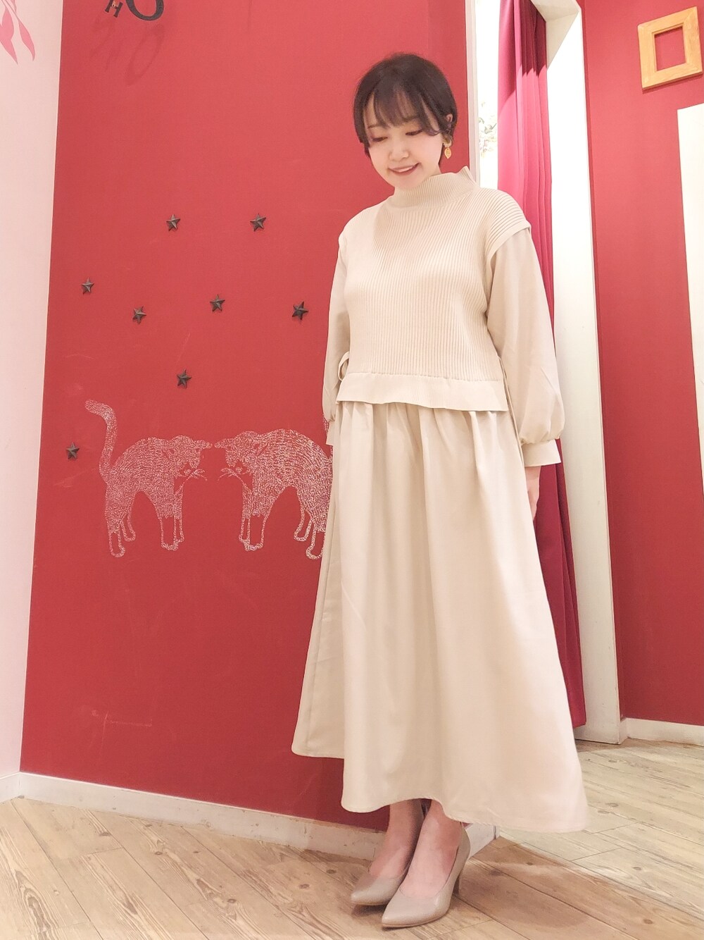 ベージュ系のワンピース、グレー系のパンプスを着用したレディースの冬コーディネートの1枚目の写真