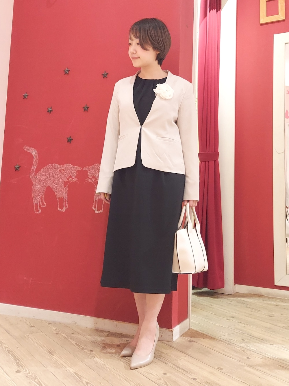 ブラック系のワンピース、ベージュ系のノーカラージャケット、ベージュ系のパンプスを着用したレディースの春コーディネートの1枚目の写真