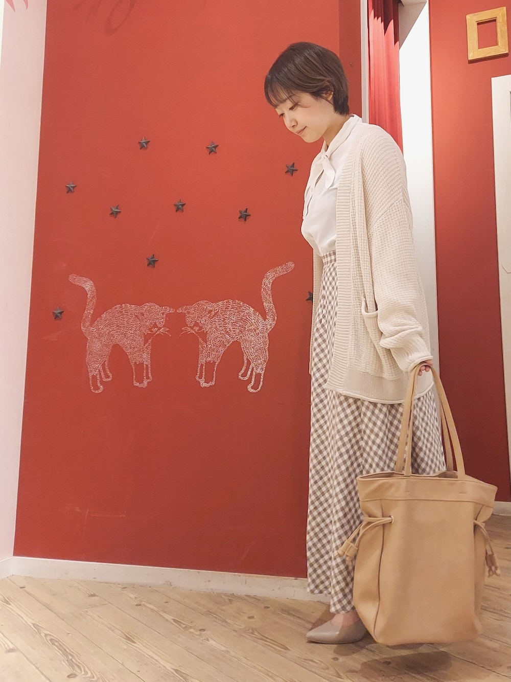 ホワイト系のシャツ/ブラウス、ホワイト系のカーディガン/ボレロ、ベージュ系のスカートを着用したレディースの春コーディネートの2枚目の写真