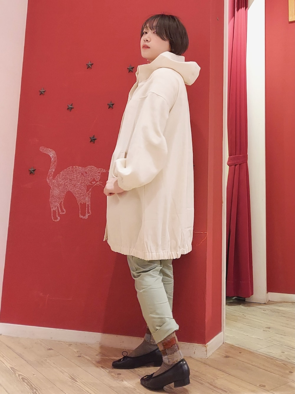 ホワイト系のその他アウター、グリーン系のパンツ、ブラック系のその他シューズを着用したレディースの冬コーディネートの2枚目の写真