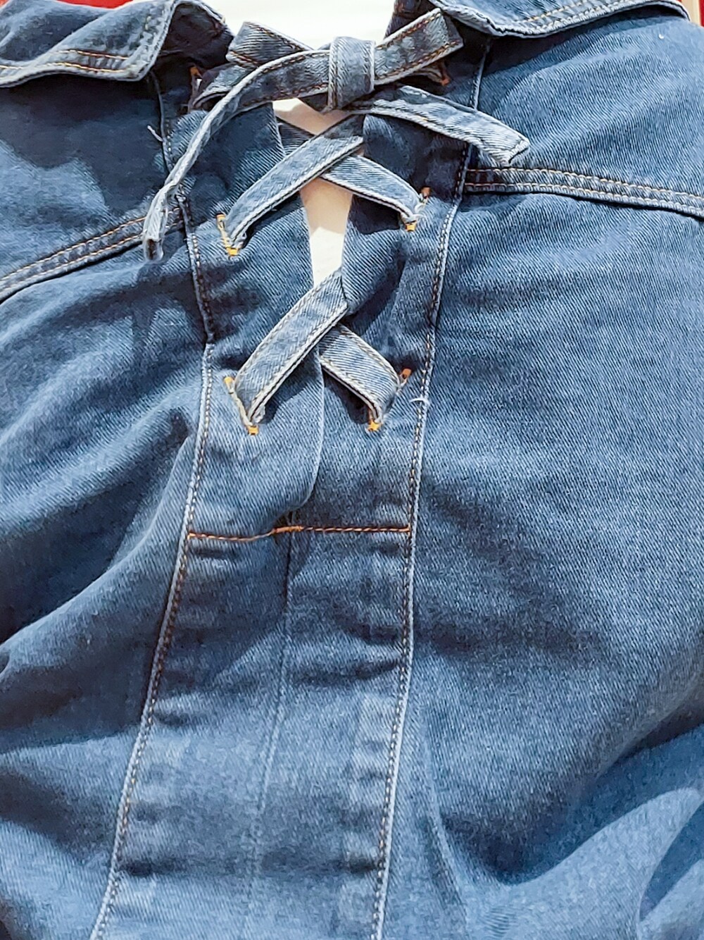 ブルー系のデニムジャケット、ブラック系のトートバッグ、ホワイト系のスウェットを着用したレディースの春コーディネートの3枚目の写真