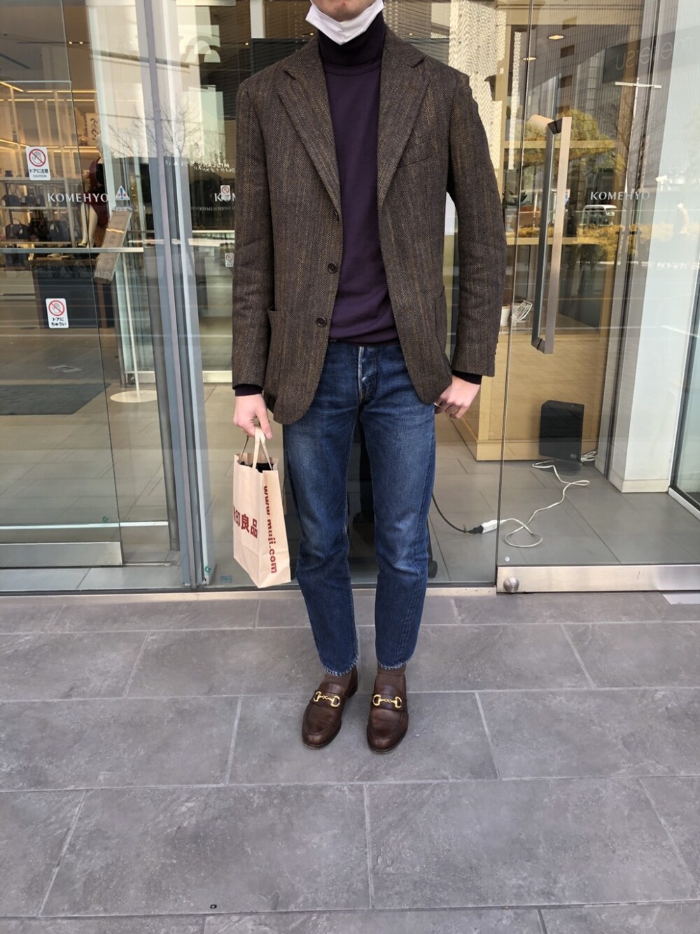 パープル系のニット/セーター、ブラウン系のテーラードジャケット、ブルー系のデニムパンツを着用したメンズの冬コーディネートの3枚目の写真