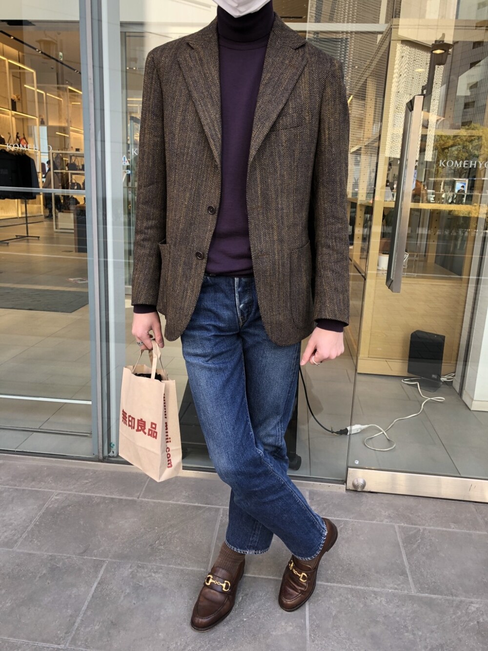 パープル系のニット/セーター、ブラウン系のテーラードジャケット、ブルー系のデニムパンツを着用したメンズの冬コーディネートの2枚目の写真