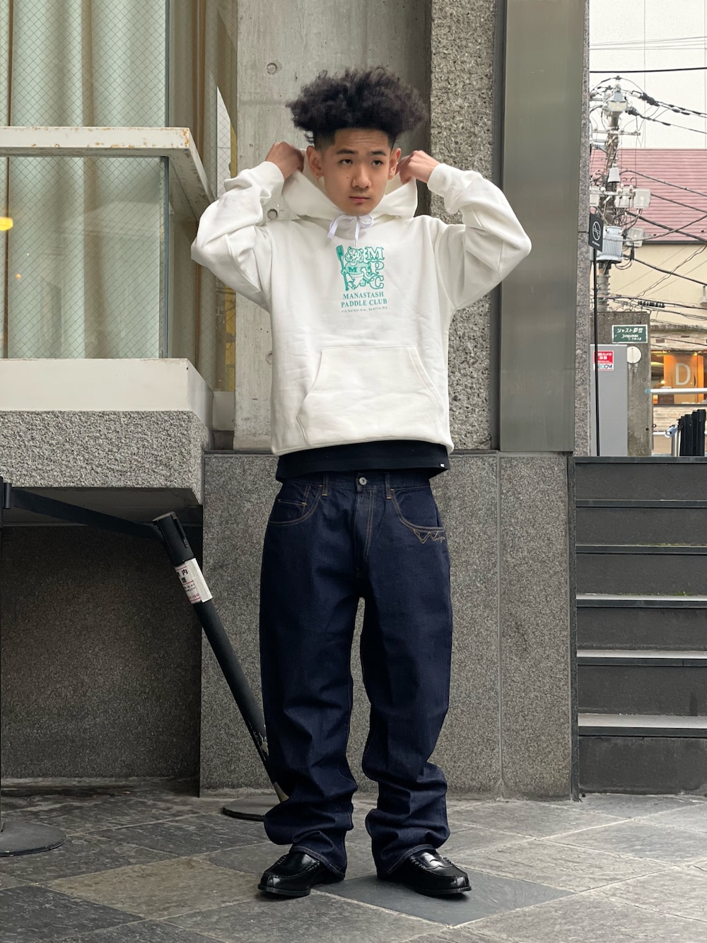 ホワイト系のパーカー、ブルー系のデニムパンツを着用したメンズの冬コーディネートの1枚目の写真
