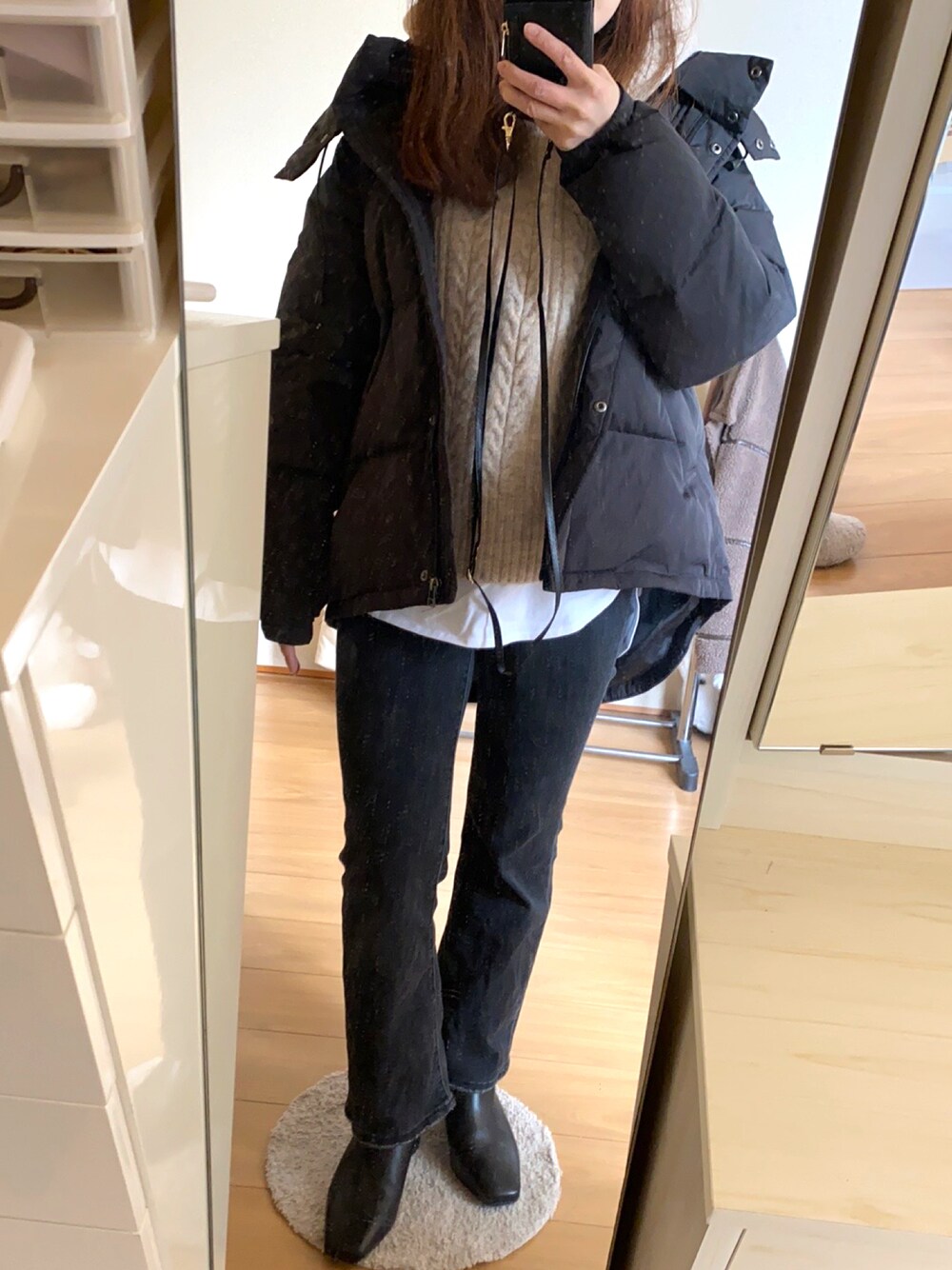 グレー系のデニムパンツ、ブラック系のブーツ、ベージュ系のニット/セーターを着用したレディースの冬コーディネートの1枚目の写真