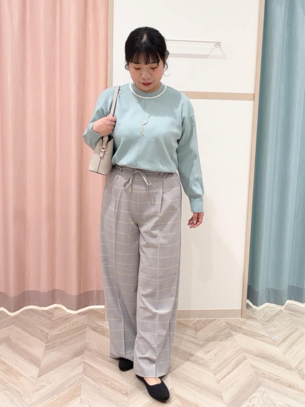 グリーン系のニット/セーター、ブラック系のその他パンツ、ブラック系のパンプスを着用したレディースの冬コーディネートの1枚目の写真