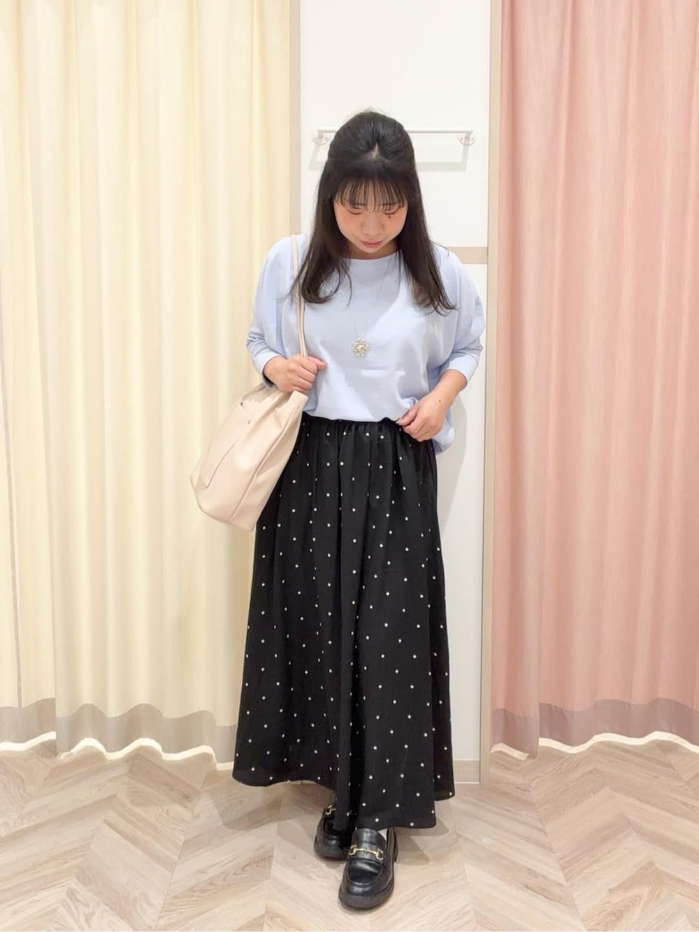 ブルー系のシャツ/ブラウス、ブラック系のスカート、ホワイト系のトートバッグを着用したレディースの春コーディネートの1枚目の写真