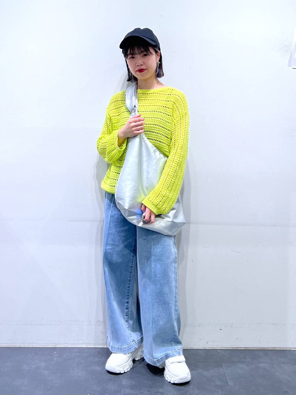 ホワイト系のスニーカー、ブルー系のデニムパンツ、ホワイト系のキャミソールを着用したレディースの春コーディネートの1枚目の写真