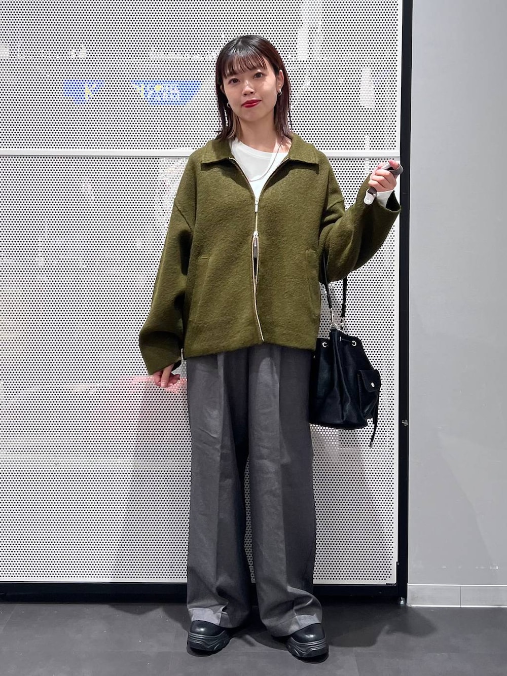 ブラック系のショルダーバッグ、ブラック系のブーツ、ホワイト系のTシャツ/カットソーを着用したレディースの秋コーディネートの1枚目の写真