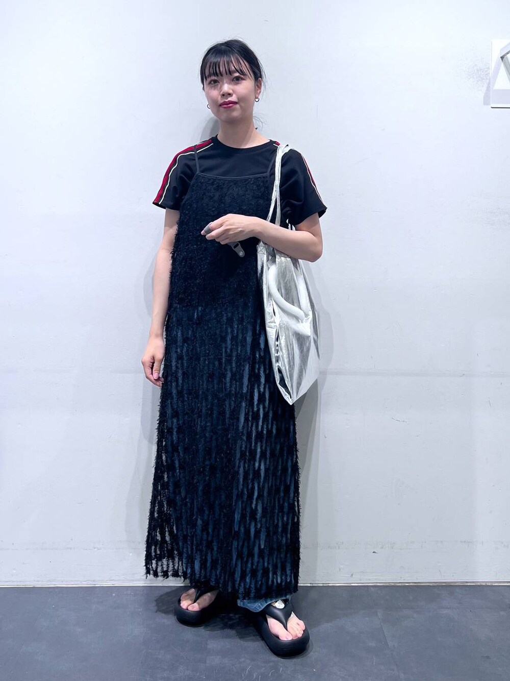 ブラック系のサンダル、シルバー系のトートバッグ、ブルー系のデニムパンツを着用したレディースの春コーディネートの1枚目の写真