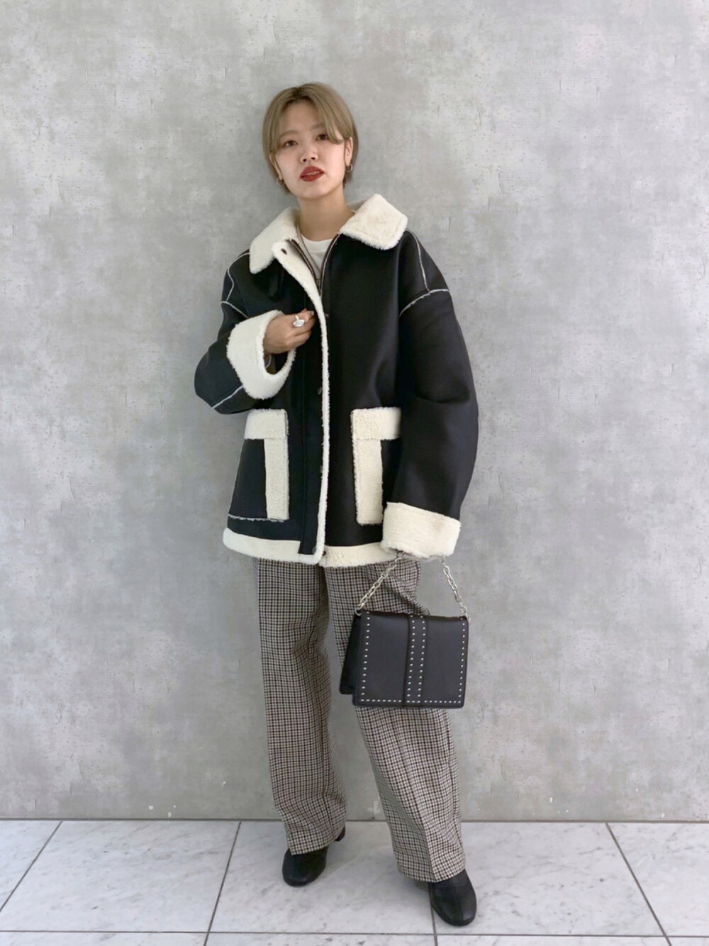 ブラック系のブーツ、ブラック系のショルダーバッグ、グレー系のその他パンツを着用したレディースの秋コーディネートの1枚目の写真