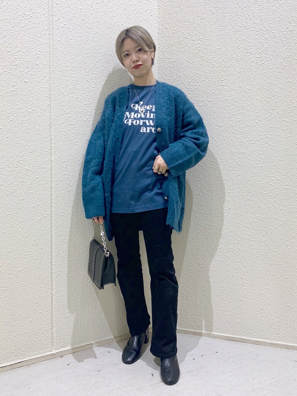 ブラック系のブーツ、グリーン系のTシャツ/カットソー、ブルー系のカーディガン/ボレロを着用したレディースの秋コーディネートの1枚目の写真