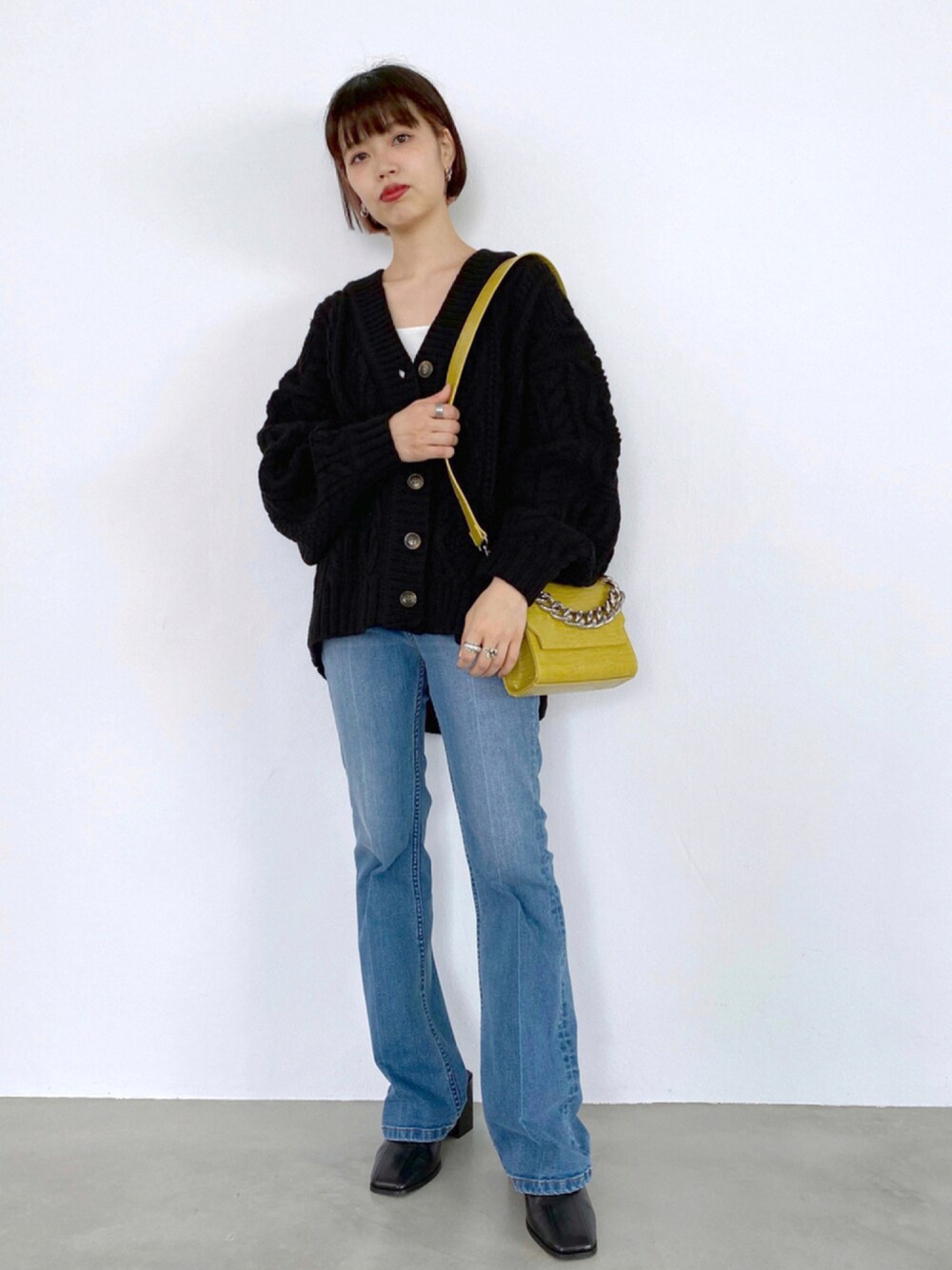 ブラック系のサンダル、ブルー系のデニムパンツ、ブラック系のニット/セーターを着用したレディースの秋コーディネートの1枚目の写真