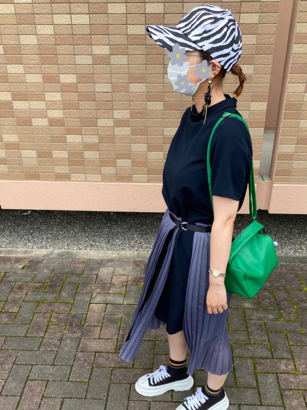 グリーン系のショルダーバッグ、ブラック系のスニーカー、ブラック系のワンピースを着用したレディースの秋コーディネートの1枚目の写真