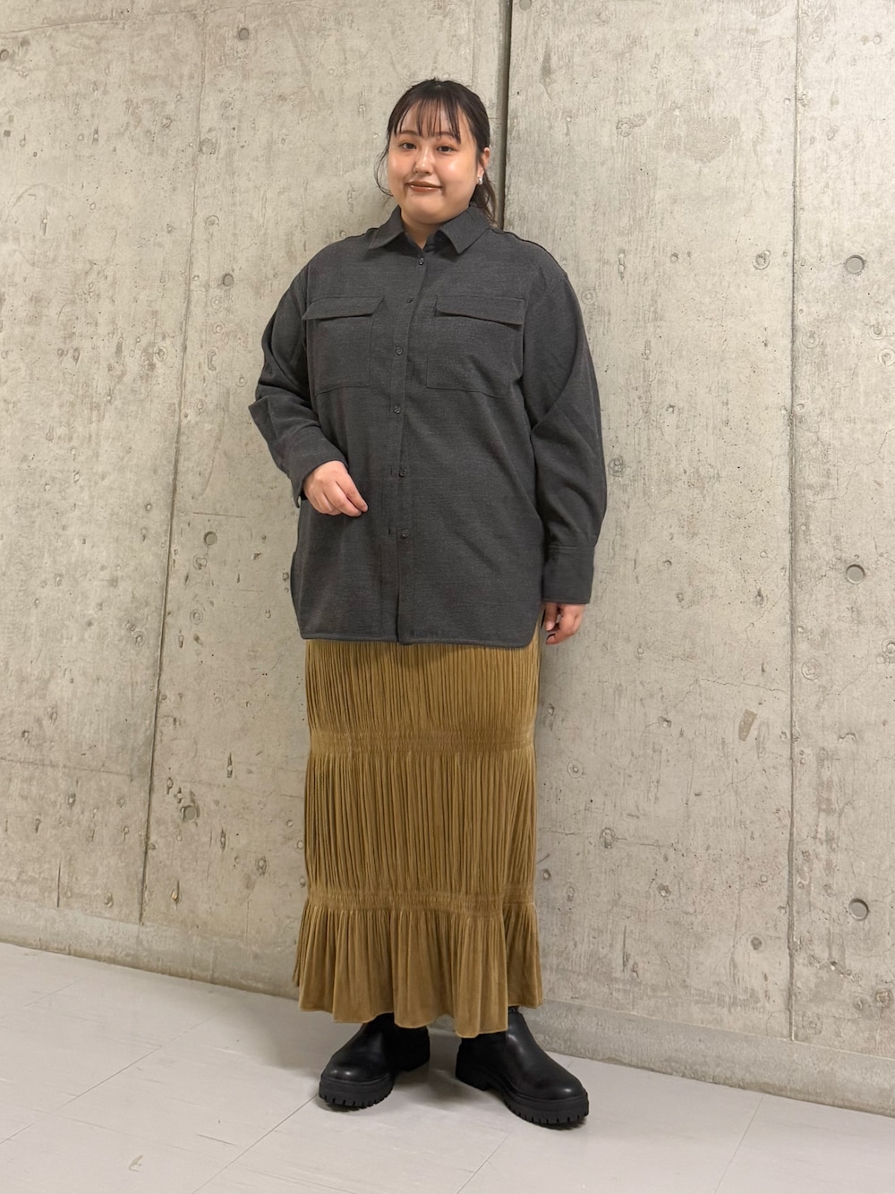 グレー系のシャツ/ブラウス、イエロー系のワンピース、ブラック系のブーツを着用したレディースの冬コーディネートの1枚目の写真