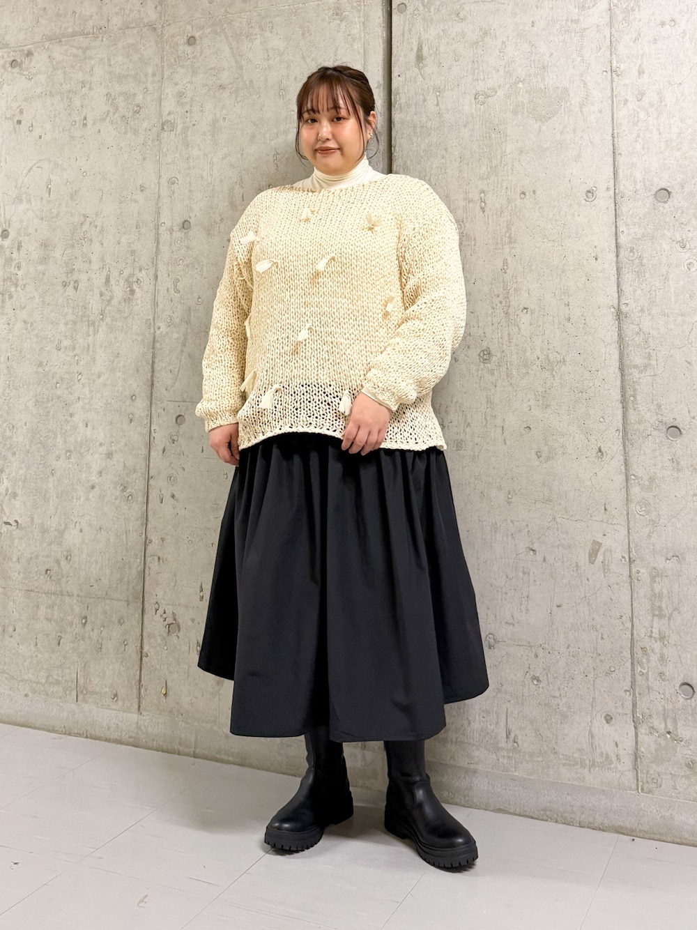 ホワイト系のTシャツ/カットソー、ホワイト系のニット/セーター、ブラック系のスカートを着用したレディースの冬コーディネートの1枚目の写真