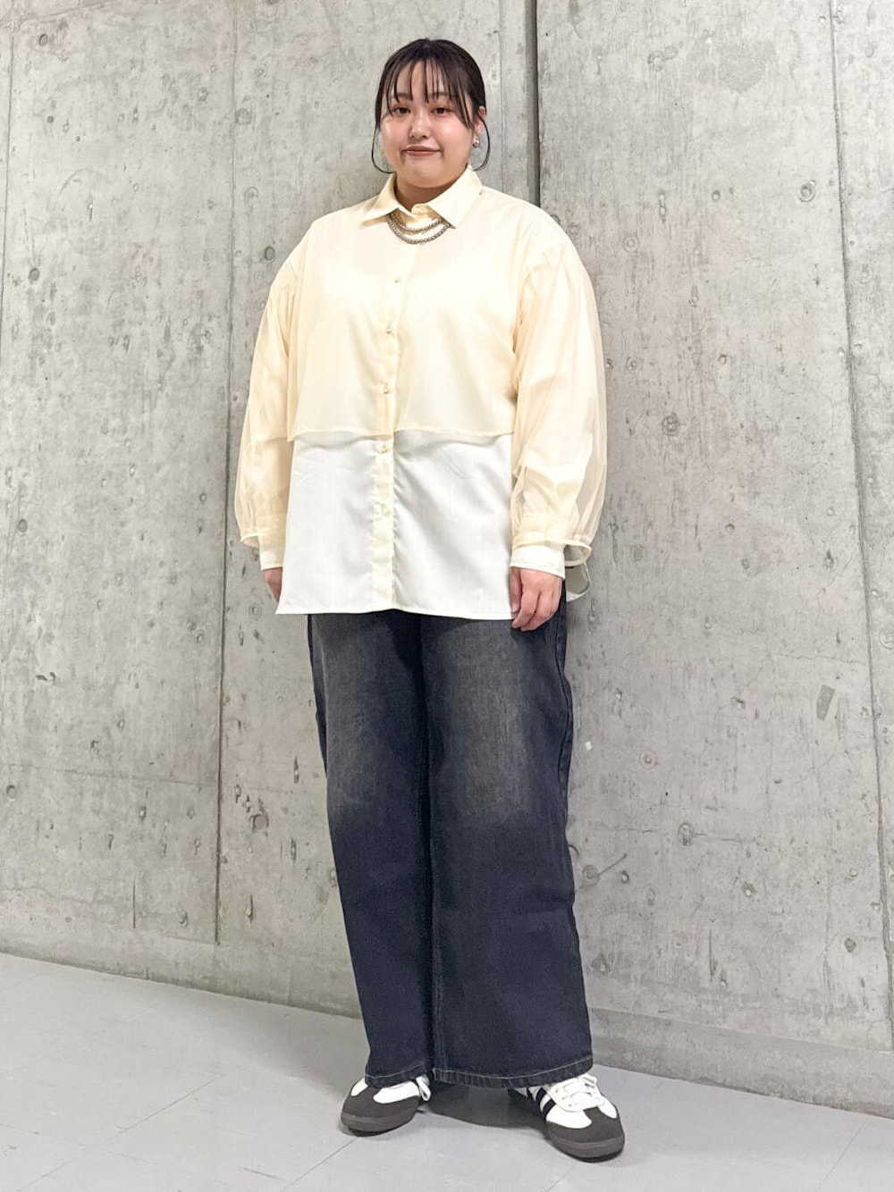 ブラック系のデニムパンツ、ベージュ系のシャツ/ブラウスを着用したレディースの春コーディネートの1枚目の写真