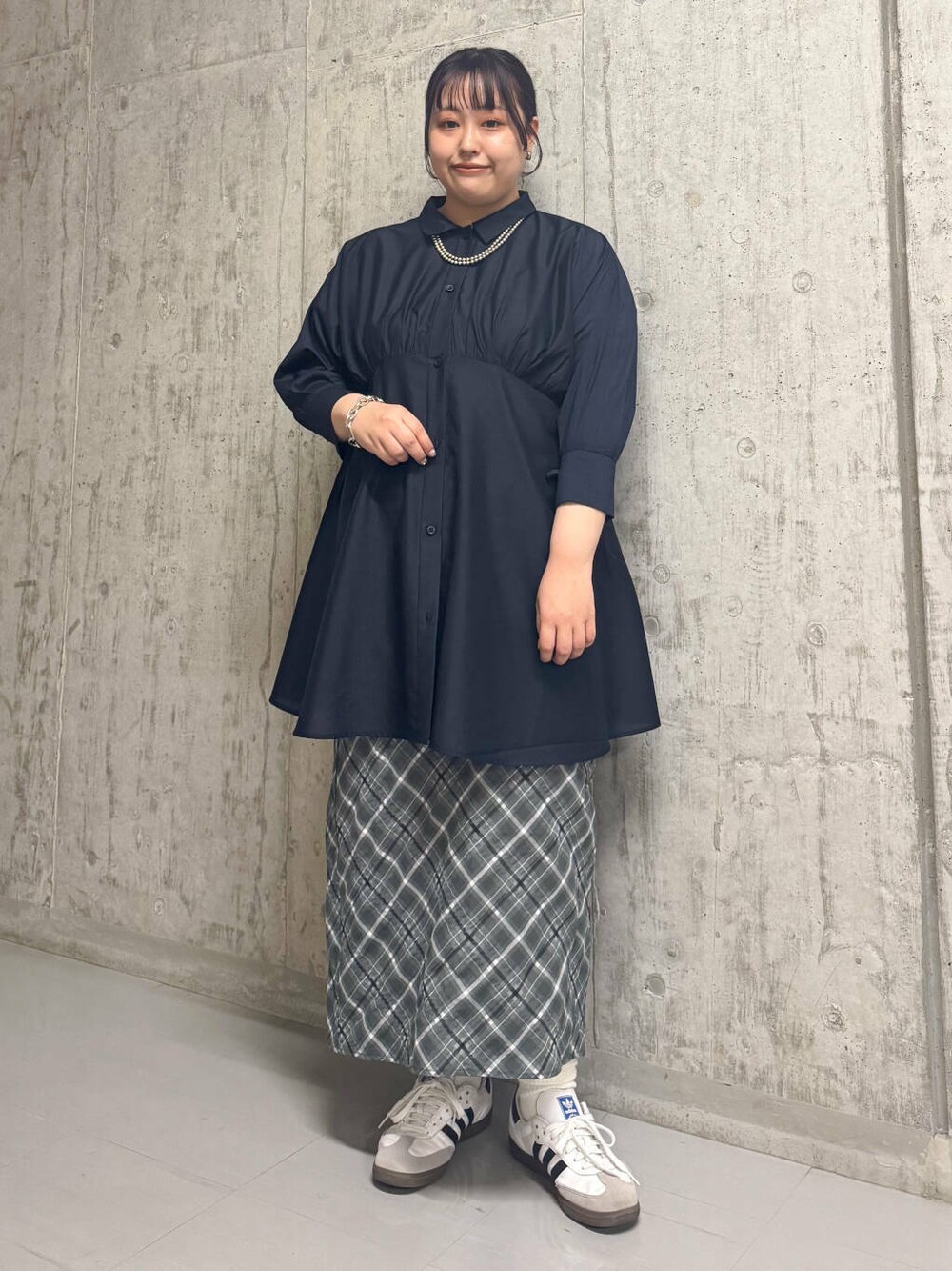 ブルー系のワンピース、グレー系のスカートを着用したレディースの春コーディネートの1枚目の写真