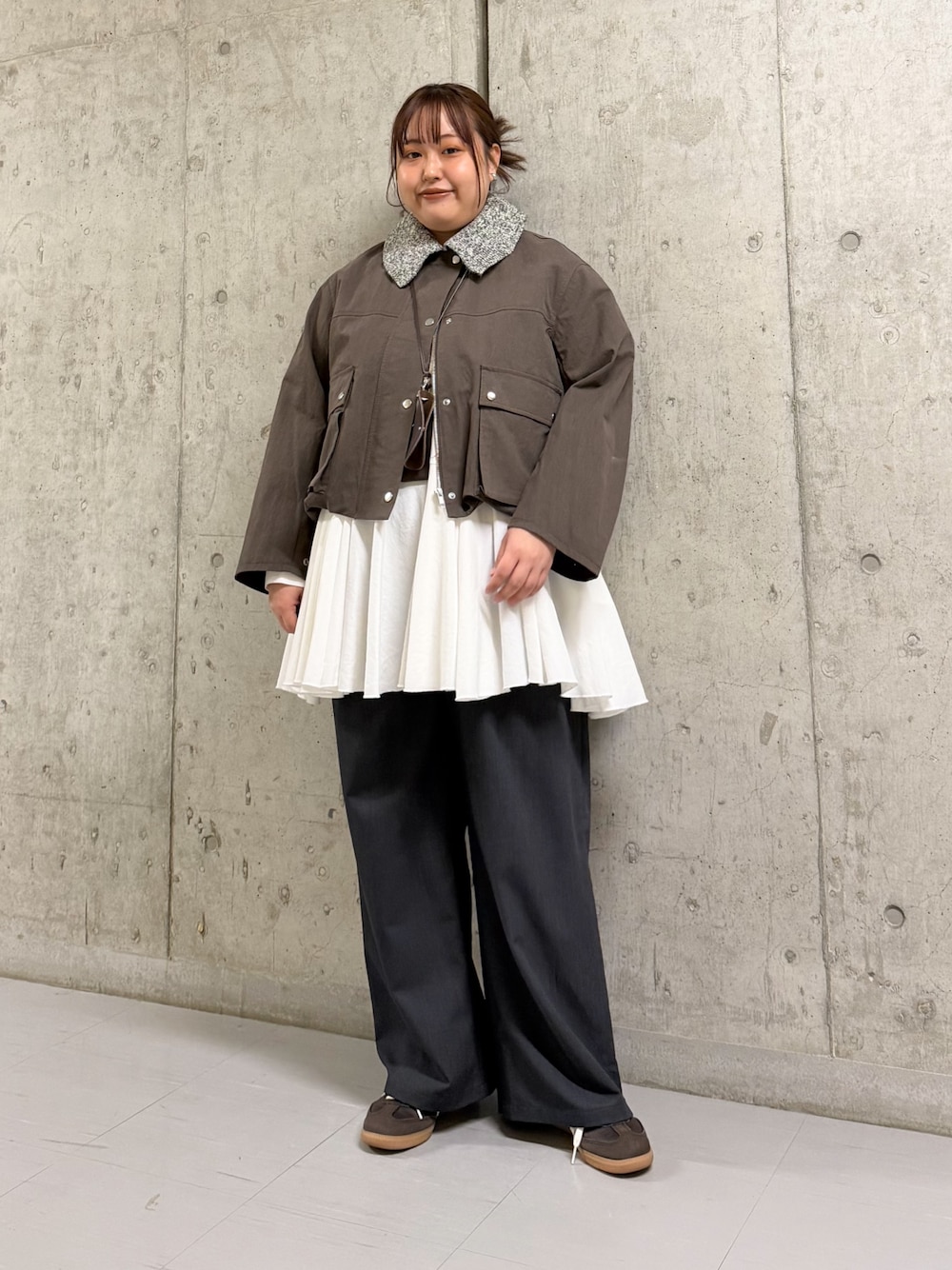 ブラウン系のブルゾン、ホワイト系のワンピース、ブラウン系のショルダーバッグを着用したレディースの冬コーディネートの1枚目の写真