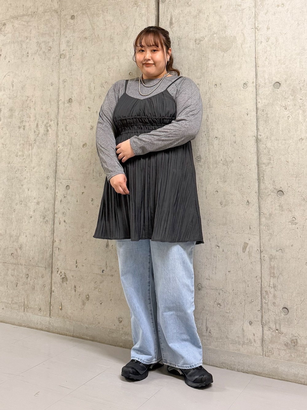 グレー系のTシャツ/カットソー、グレー系のワンピース、ブルー系のデニムパンツを着用したレディースの春コーディネートの1枚目の写真