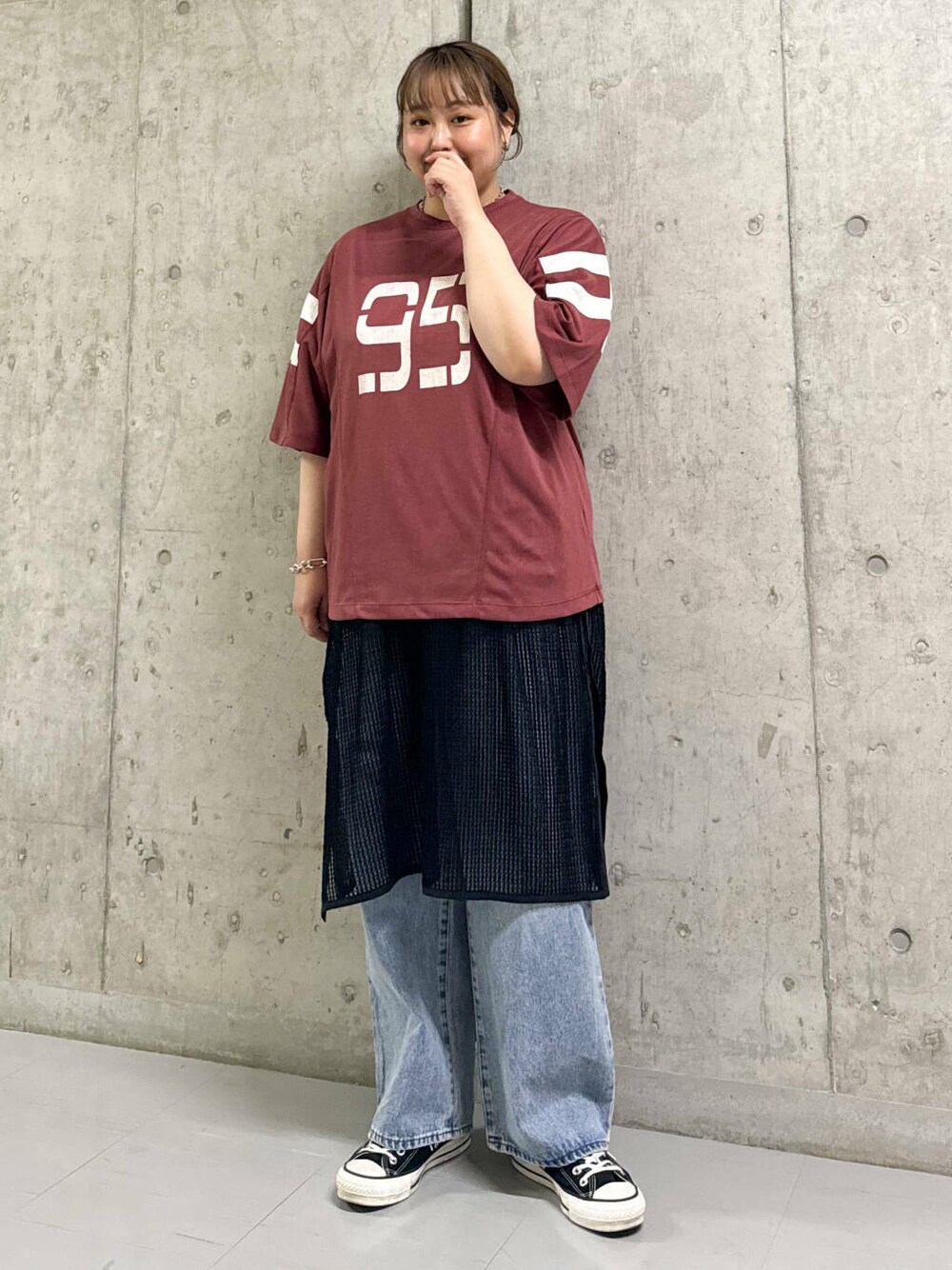 ブルー系のデニムパンツ、ブラック系のワンピース、レッド系のTシャツ/カットソーを着用したレディースの夏コーディネートの1枚目の写真