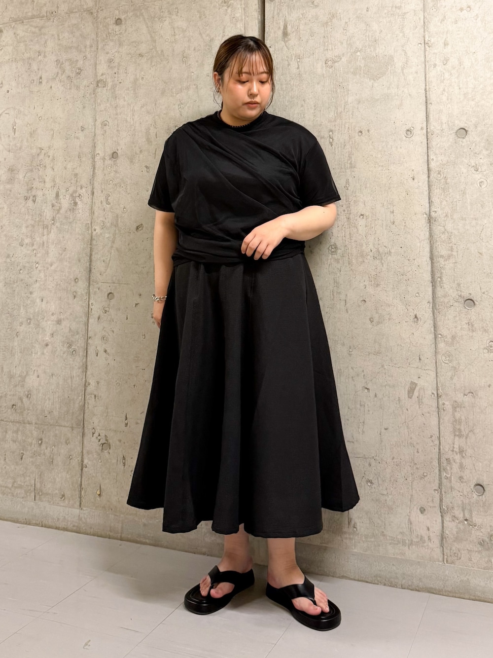 ブラック系のTシャツ/カットソー、ブラック系のスカート、ブラック系のサンダルを着用したレディースの夏コーディネートの1枚目の写真
