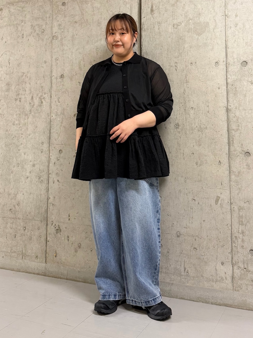 ブラック系のシャツ/ブラウス、ブラック系のチュニック、ブルー系のデニムパンツを着用したレディースの春コーディネートの1枚目の写真