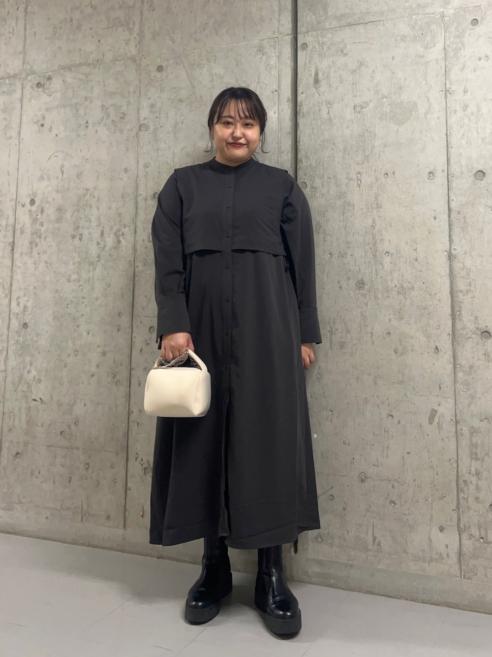 グレー系のワンピース、ホワイト系のハンドバッグを着用したレディースの秋コーディネートの1枚目の写真