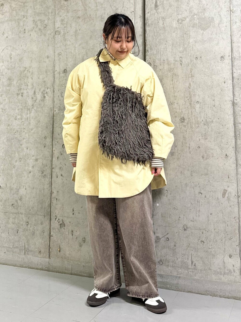 ブラウン系のショルダーバッグ、ベージュ系のダウンジャケット/コート、ブラウン系のデニムパンツを着用したレディースの冬コーディネートの1枚目の写真