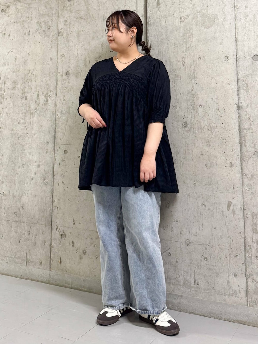 ブルー系のデニムパンツ、ブラック系のワンピースを着用したレディースの春コーディネートの1枚目の写真