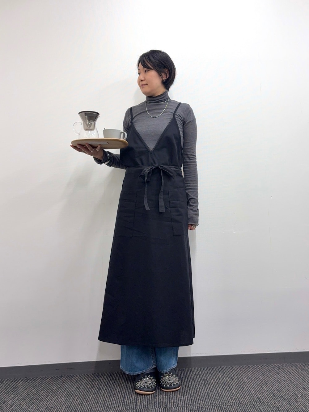 「エプロン、タートルネック、デニム、バブーシュ、おうちファッション、おうち時間、オトナカジュアル」｜「collexの＜高山都×collex＞コラボ おもてなし2WAYエプロン（エプロン、ブラック系）」を使った、fukuさん（レディース・166cm）の冬コーディネートの1枚目の写真