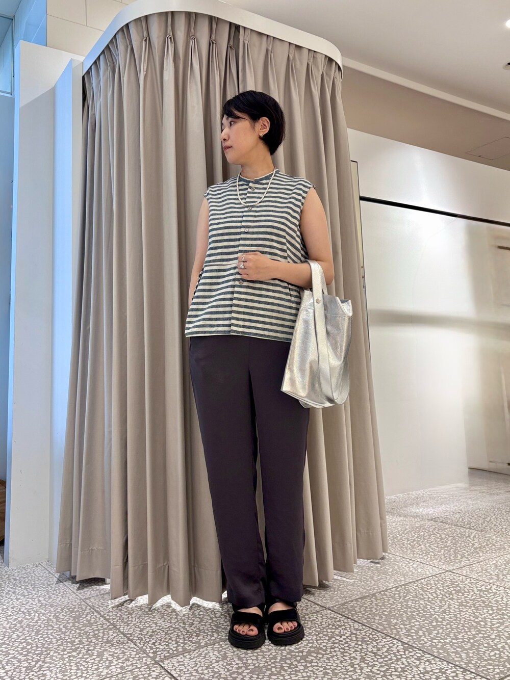 シルバー系のトートバッグ、グレー系のその他パンツ、ブラック系のサンダルを着用したレディースの夏コーディネートの1枚目の写真