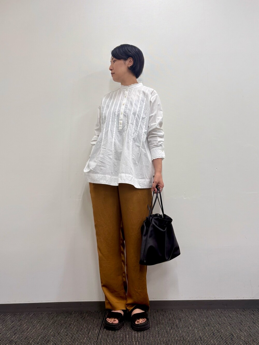 ブラウン系のその他パンツ、ブラック系のショルダーバッグ、ホワイト系のシャツ/ブラウスを着用したレディースの秋コーディネートの1枚目の写真