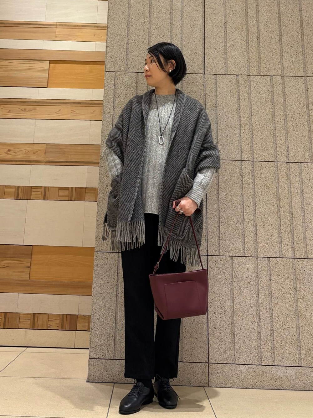 グレー系のニット/セーター、レッド系のショルダーバッグ、ブラック系のその他パンツを着用したレディースの秋コーディネートの1枚目の写真