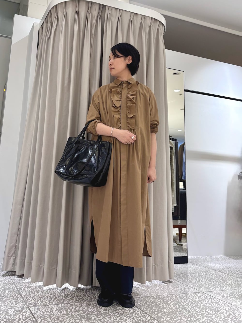 ブラウン系のシャツワンピース、ブラック系のトートバッグ、ブラック系のその他パンツを着用したレディースの秋コーディネートの1枚目の写真