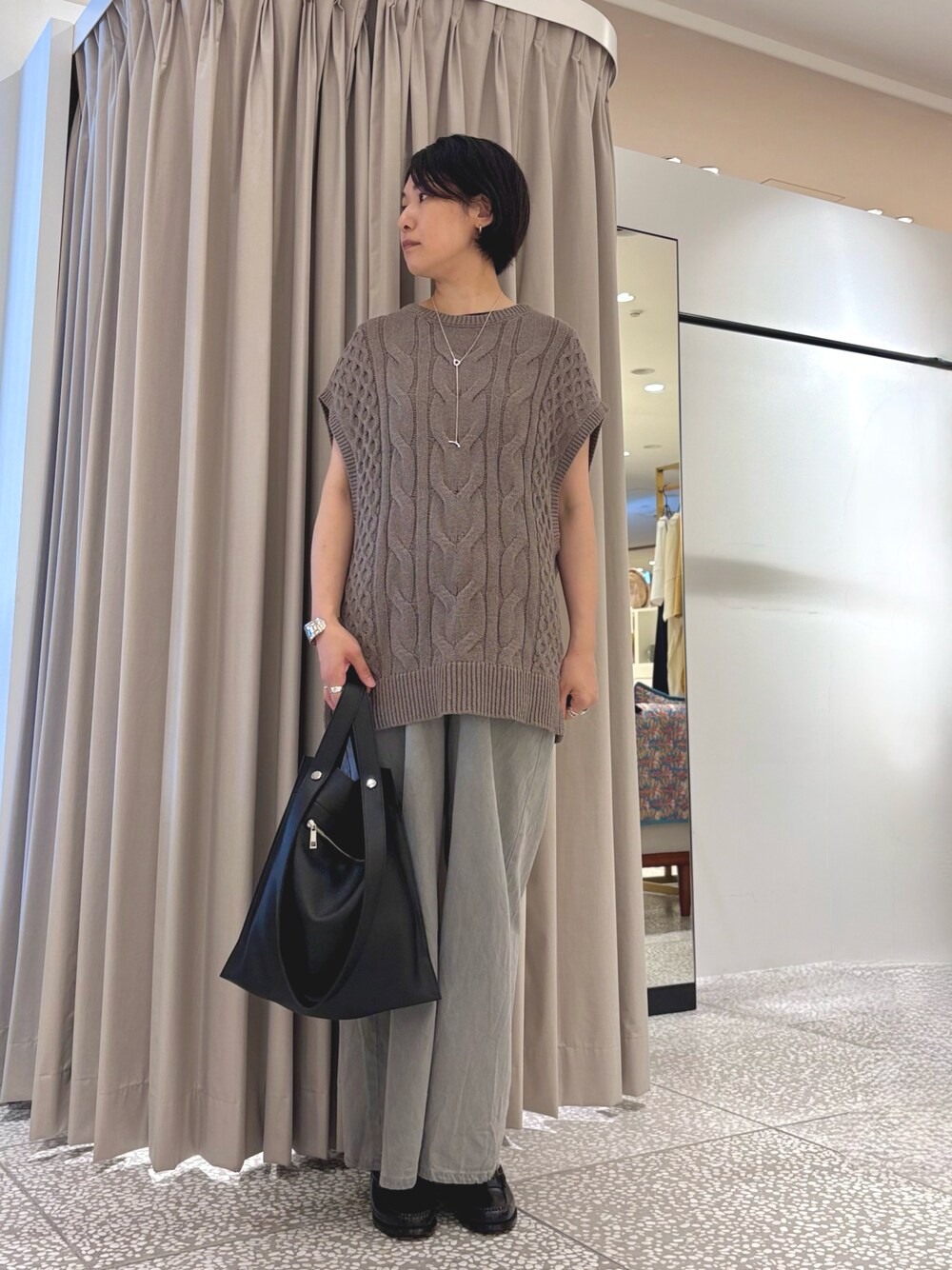 ベージュ系のニット/セーター、グレー系のデニムパンツ、ブラック系のトートバッグを着用したレディースの秋コーディネートの1枚目の写真