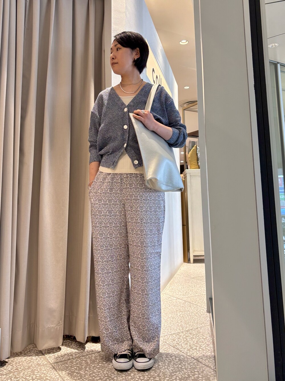 ブルー系のカーディガン/ボレロ、ブラック系のその他パンツ、シルバー系のトートバッグを着用したレディースの春コーディネートの1枚目の写真