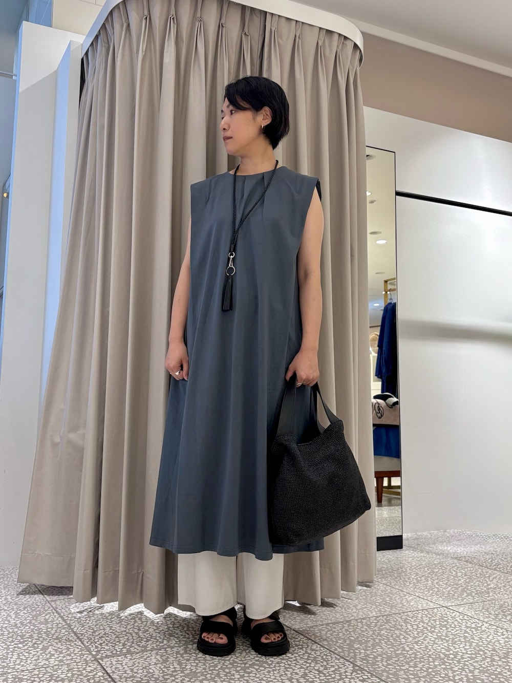 ブルー系のワンピース、ブラック系のショルダーバッグ、ホワイト系のデニムパンツを着用したレディースの夏コーディネートの1枚目の写真