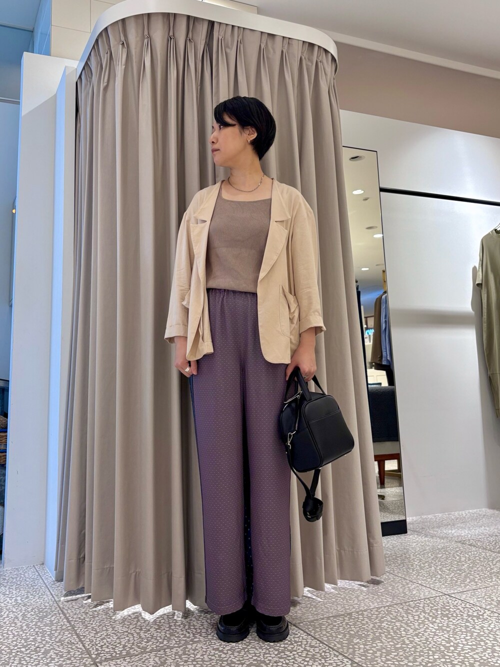 ベージュ系のテーラードジャケット、グレー系のその他パンツ、ブラック系のボストンバッグを着用したレディースの秋コーディネートの1枚目の写真