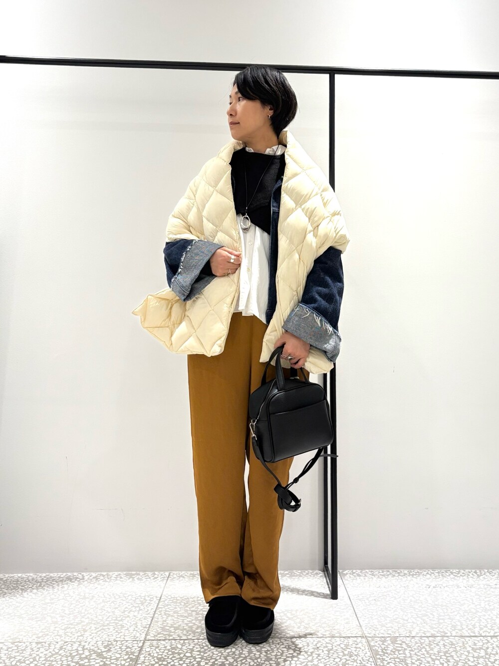 ブラック系のニット/セーター、ホワイト系のシャツ/ブラウス、ブルー系のデニムジャケットを着用したレディースの秋コーディネートの1枚目の写真