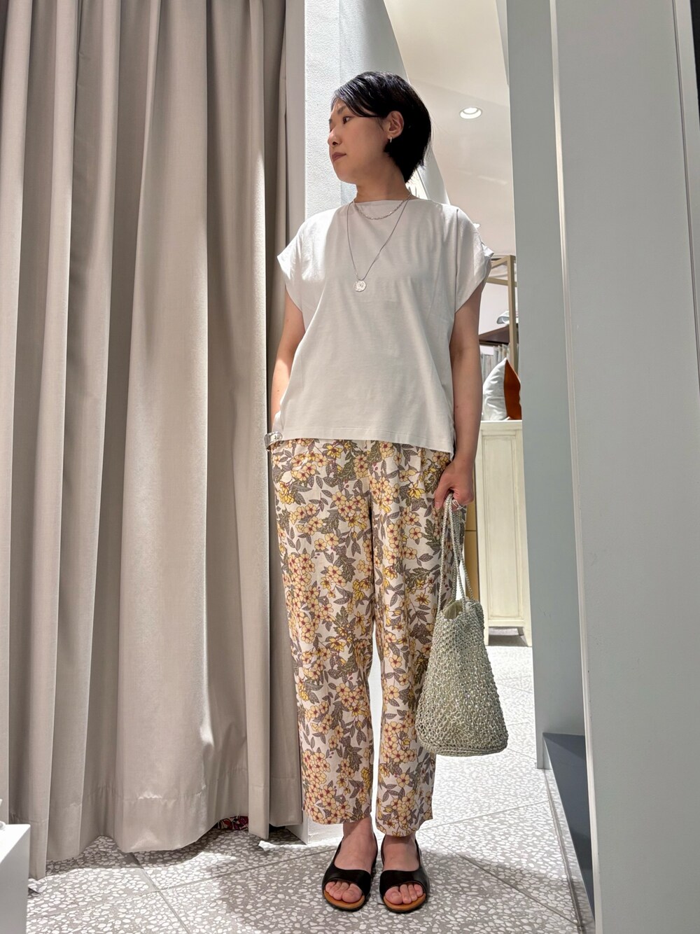 グレー系のTシャツ/カットソー、イエロー系のその他パンツ、ゴールド系のかごバッグを着用したレディースの春コーディネートの1枚目の写真