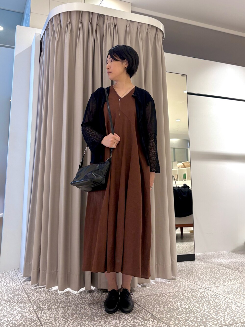 ブラウン系のワンピース、ブラック系のカーディガン/ボレロ、ブラック系のショルダーバッグを着用したレディースの秋コーディネートの1枚目の写真