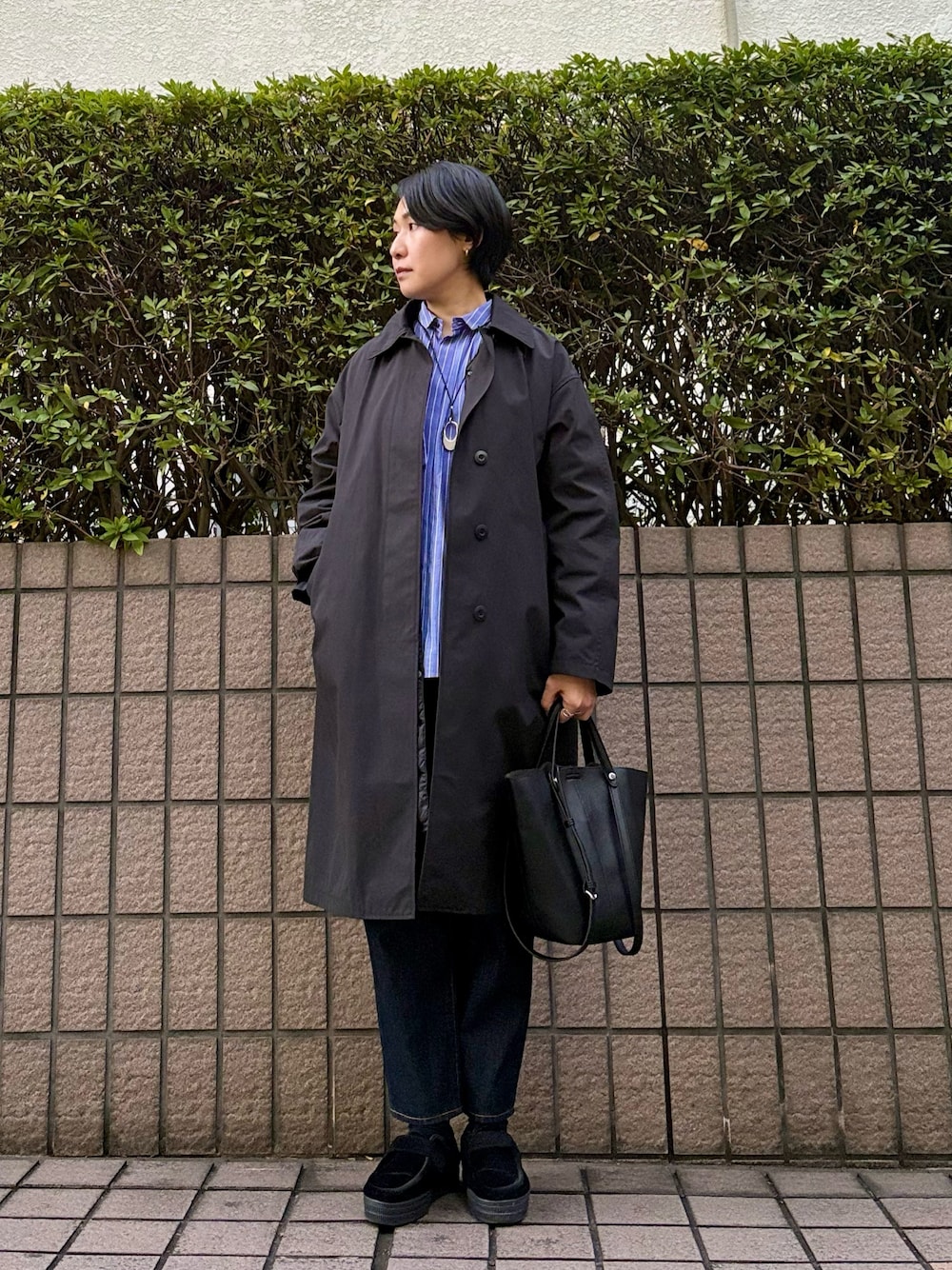 ブラック系のトートバッグ、ブラック系のローファー、ブルー系のデニムパンツを着用したレディースの秋コーディネートの1枚目の写真