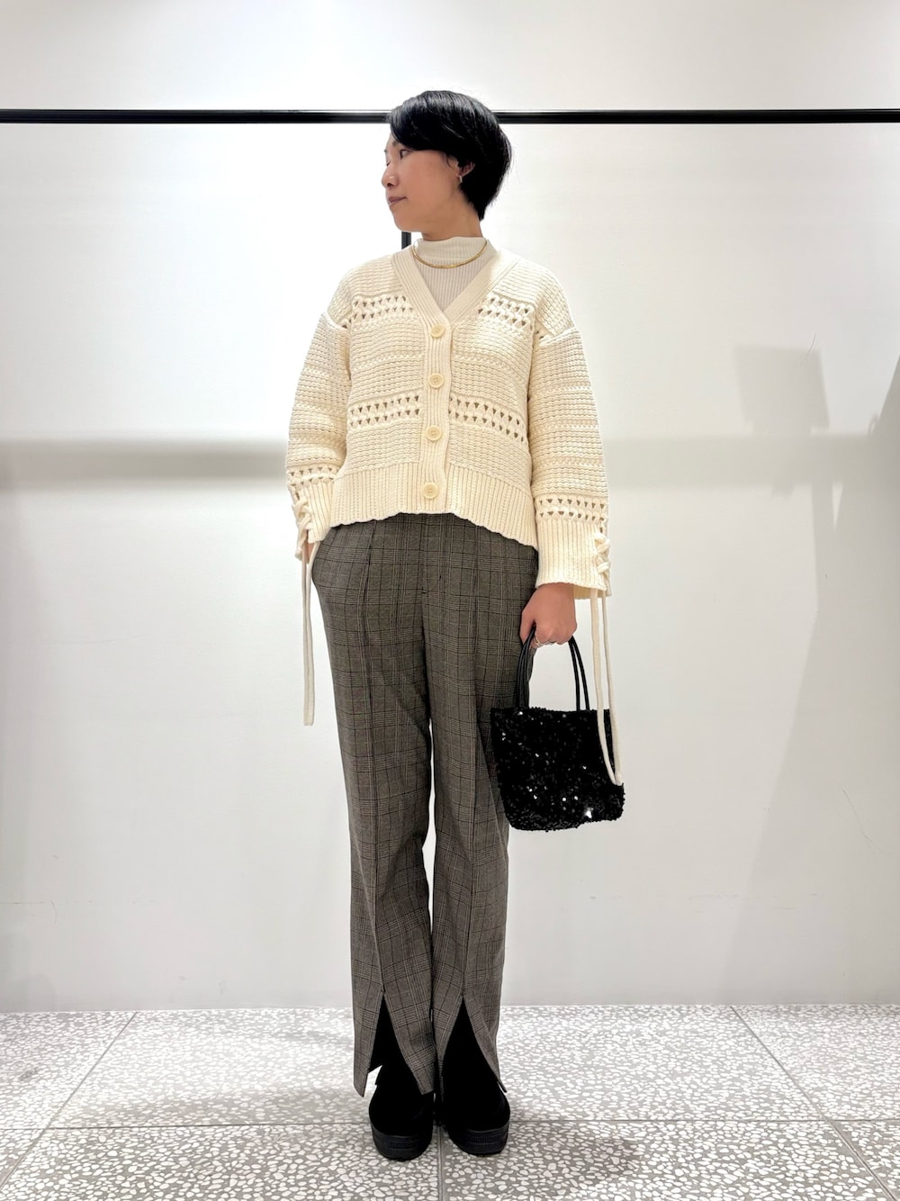 ホワイト系のカーディガン/ボレロ、その他のスラックス、ブラック系のショルダーバッグを着用したレディースの冬コーディネートの1枚目の写真